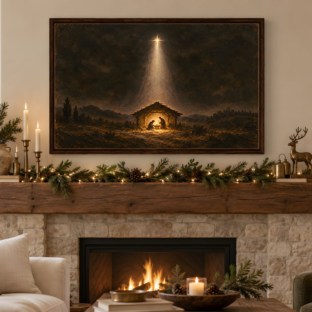 A large framed Christmas nativity painting hangs on a wall above a stone fireplace with a lit fire, decorated with green garlands, candles, pinecones, and a small deer figurine. A sofa and armchair are visible in the room.