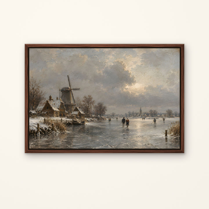 A framed landscape painting of a snowy winter scene with a windmill, small houses, and people skating on a frozen river under a cloudy sky, displayed against a light beige wall.
